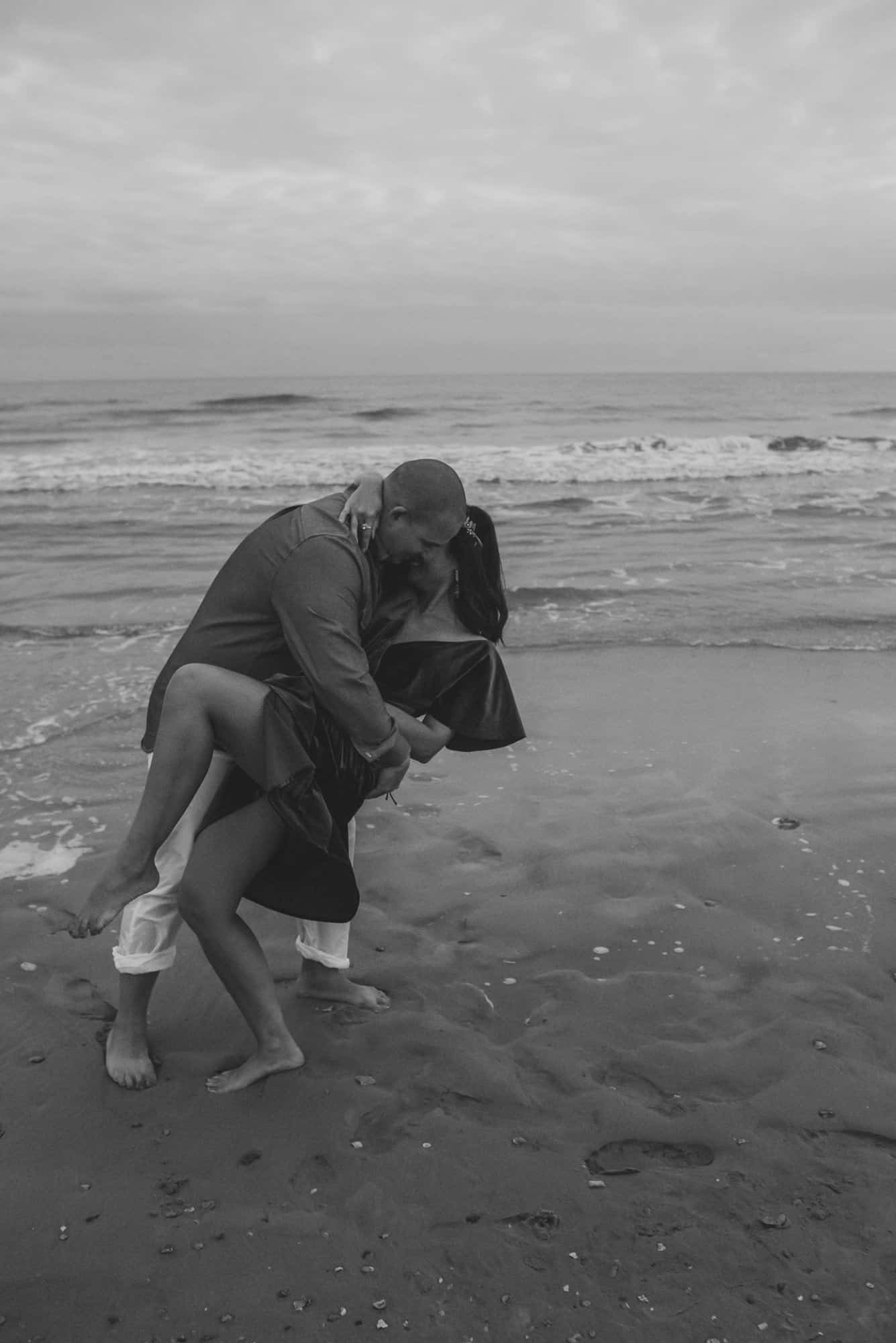 couple doing a dip kiss on the beach