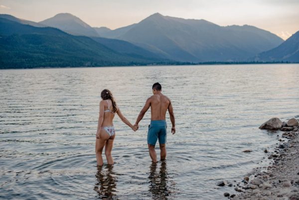 Couple playing in water in an alpine lake celebrating their anniversary