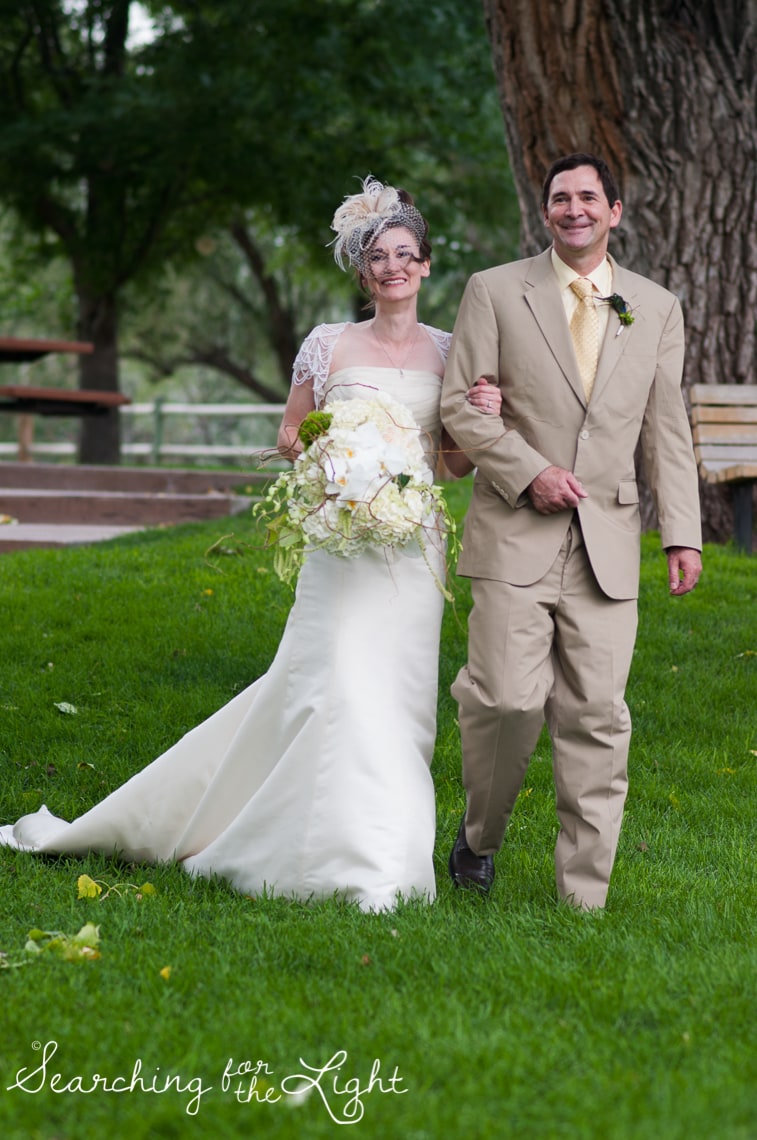 walking down aisle Lakewood stone house wedding photos by Denver wedding photographer searchingforthelight.com
