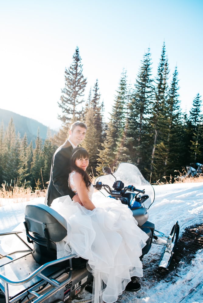 wedding couple on snowmobile on mountain top