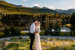 couple holding hands at their sprague lake wedding in rocky mountain national park near sunset