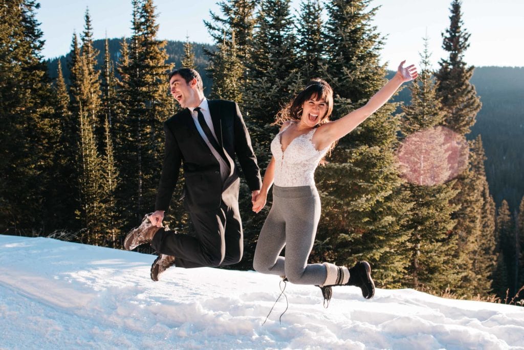 couple jumping in their wedding clothes