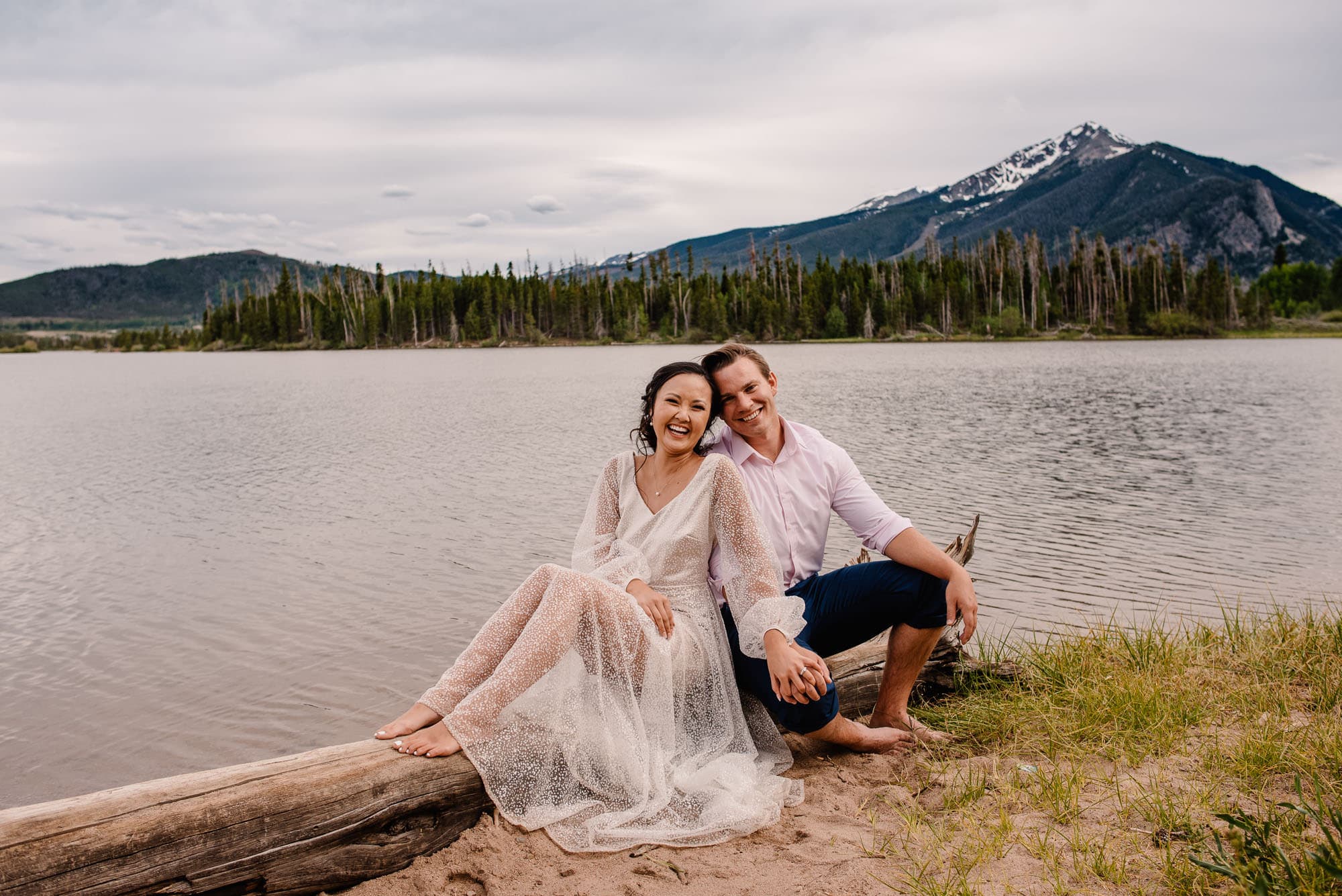 couple on a beachside smiling at their Oregon elopement photographers