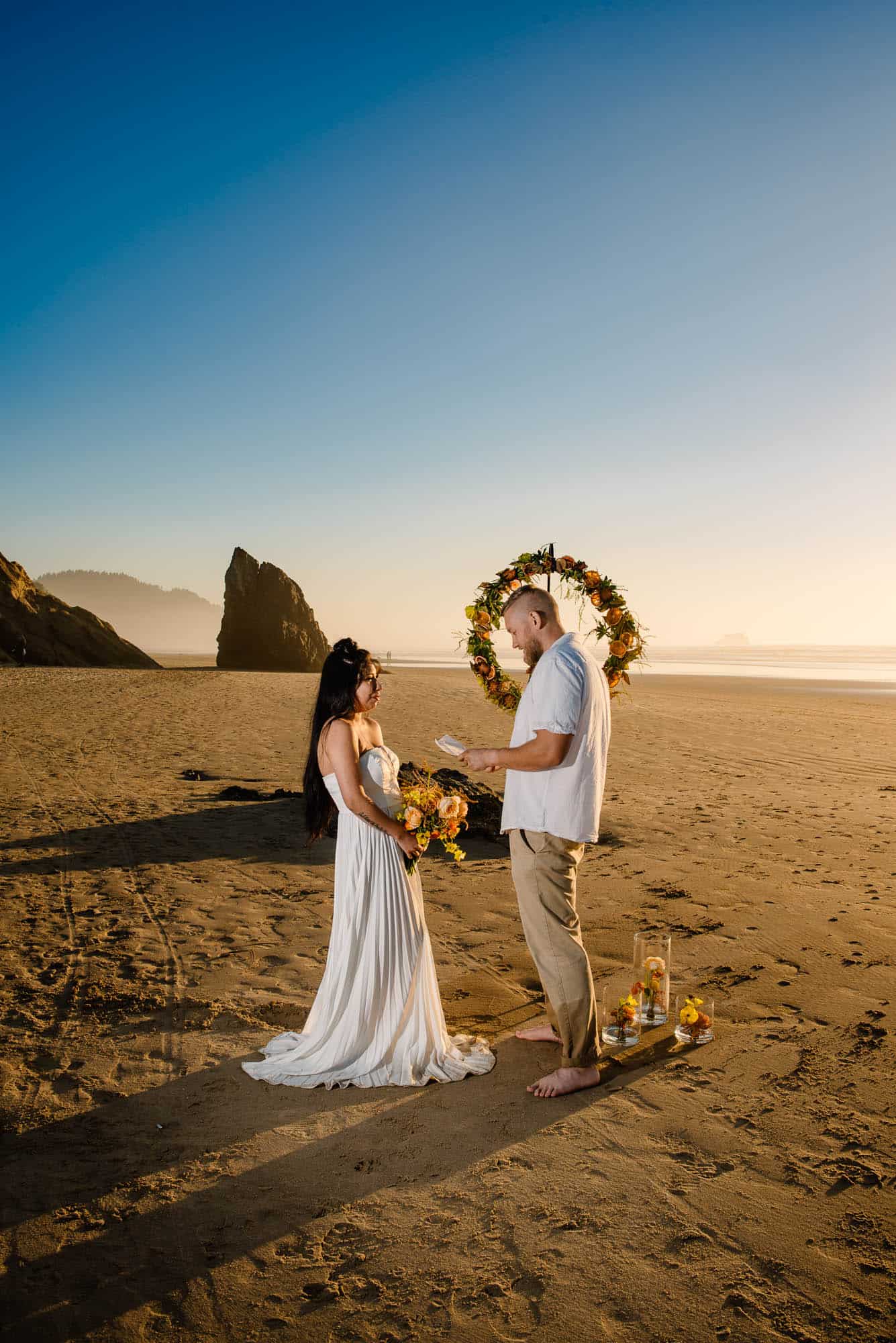 eloping couple exchanging their vows on the beach at sunset