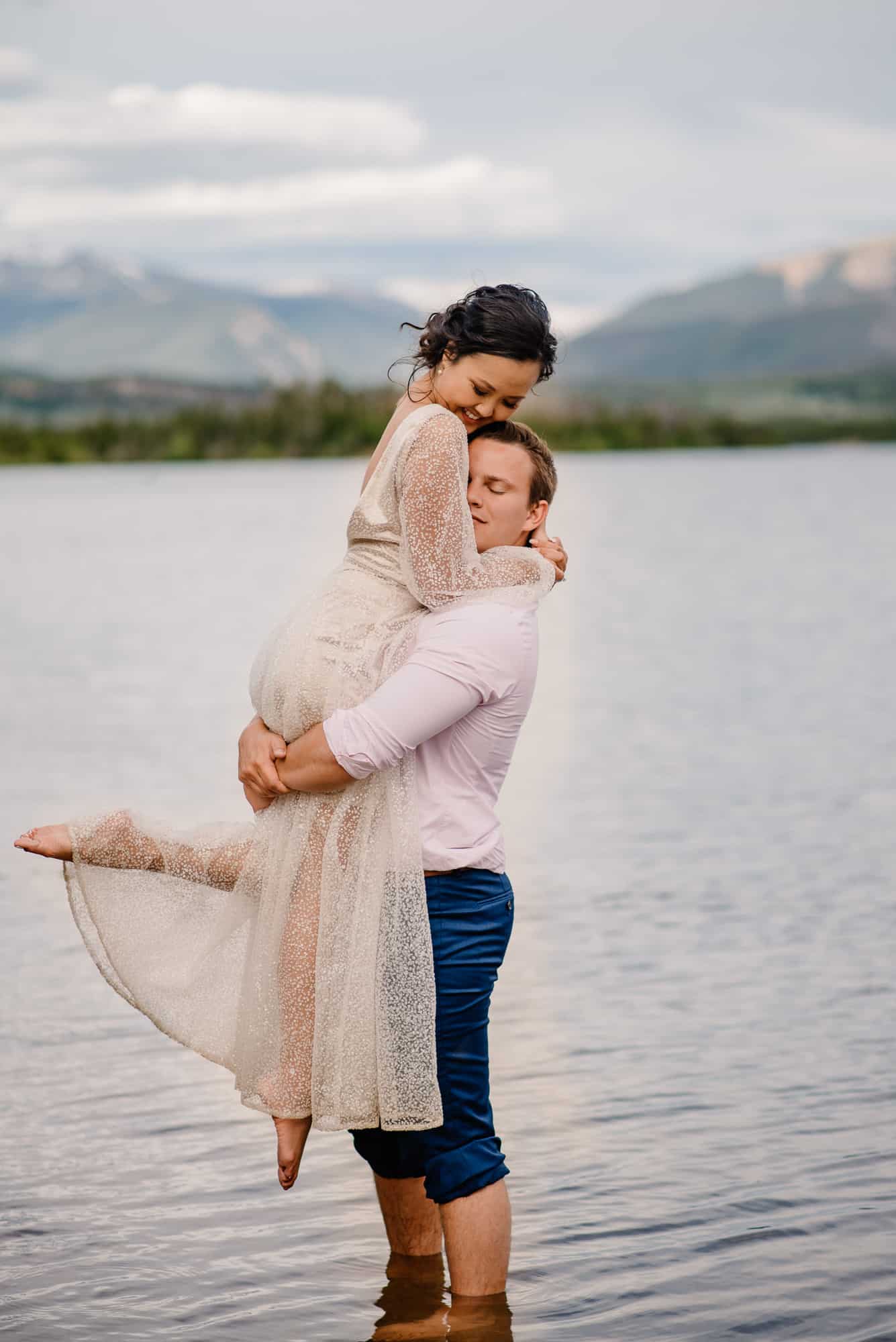 couple playing in the water on their wedding day