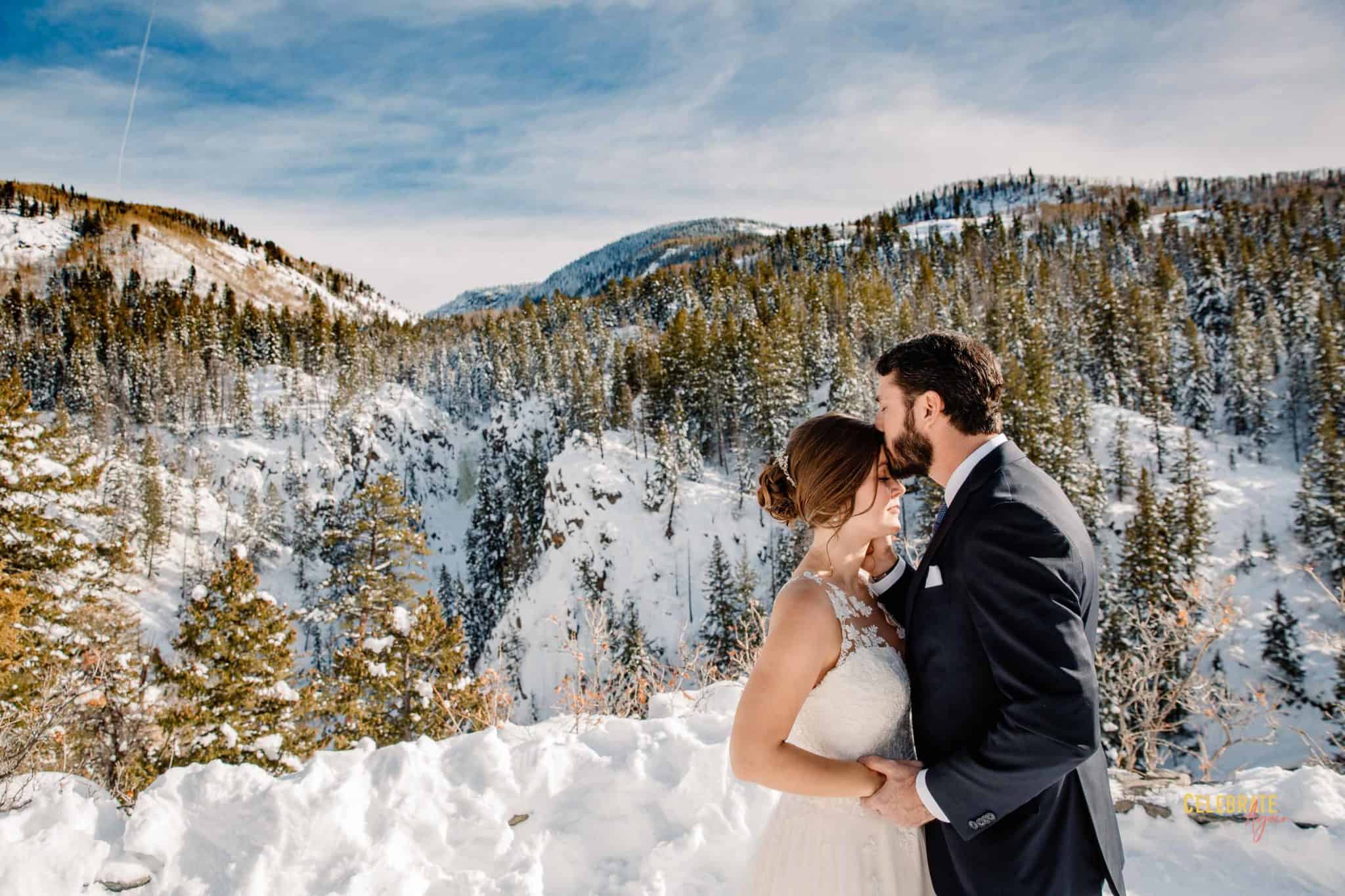groom kissing bride at fish creek falls
