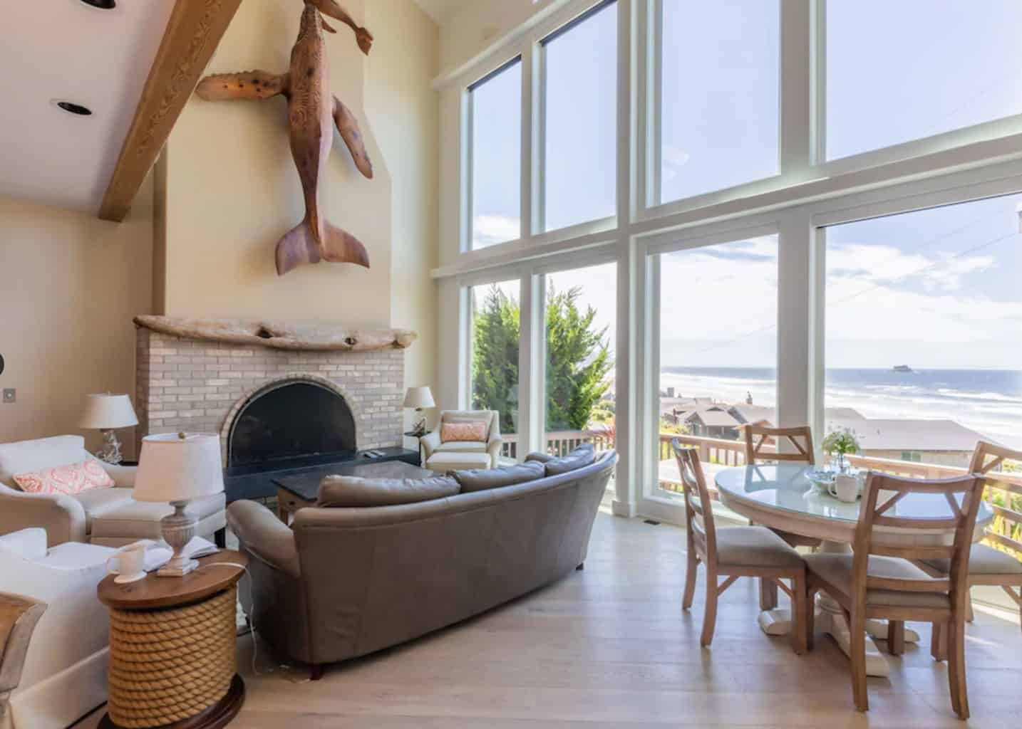 tall ocean front windows with wood floor living room and fire place