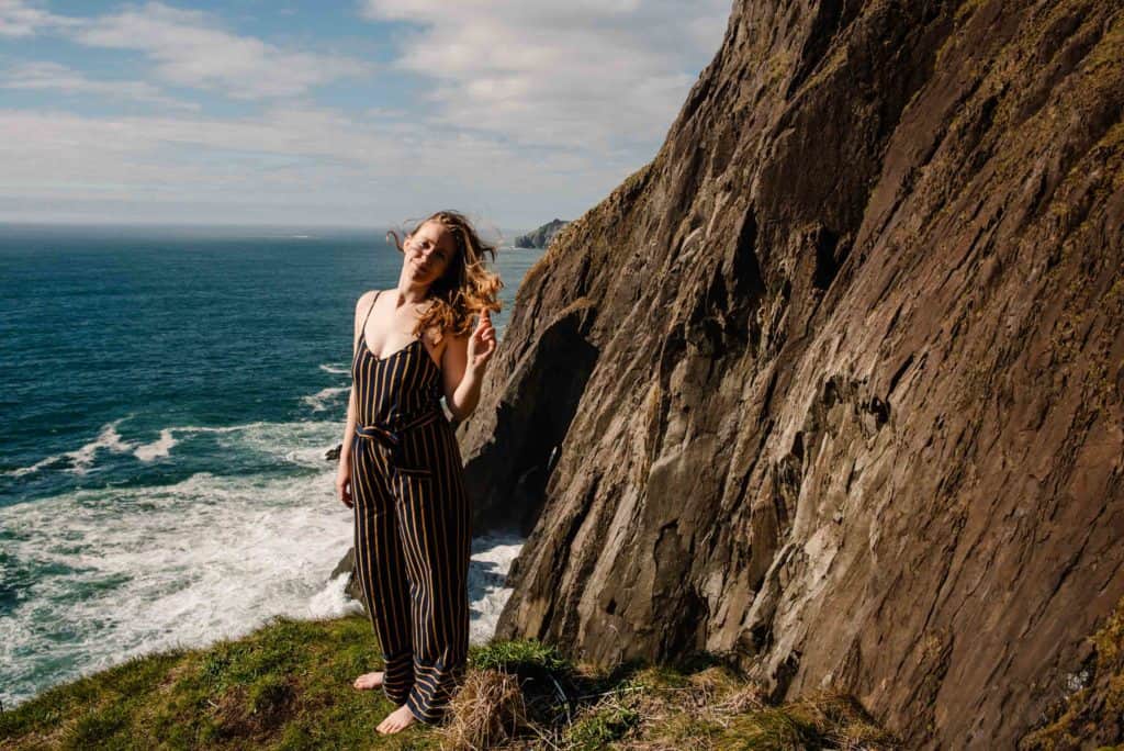 Lumalia standing near a coastline with her hair blowing in the wind