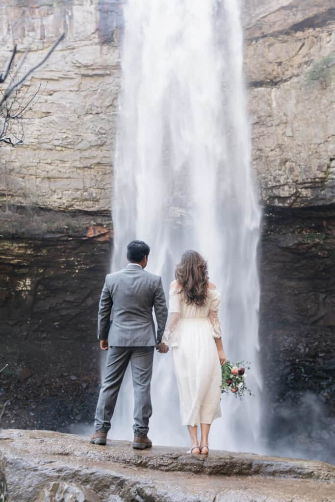 fall creek falls waterfall wedding venue with a couple standing in front of a waterfall photo by Jessica Kovach Photography