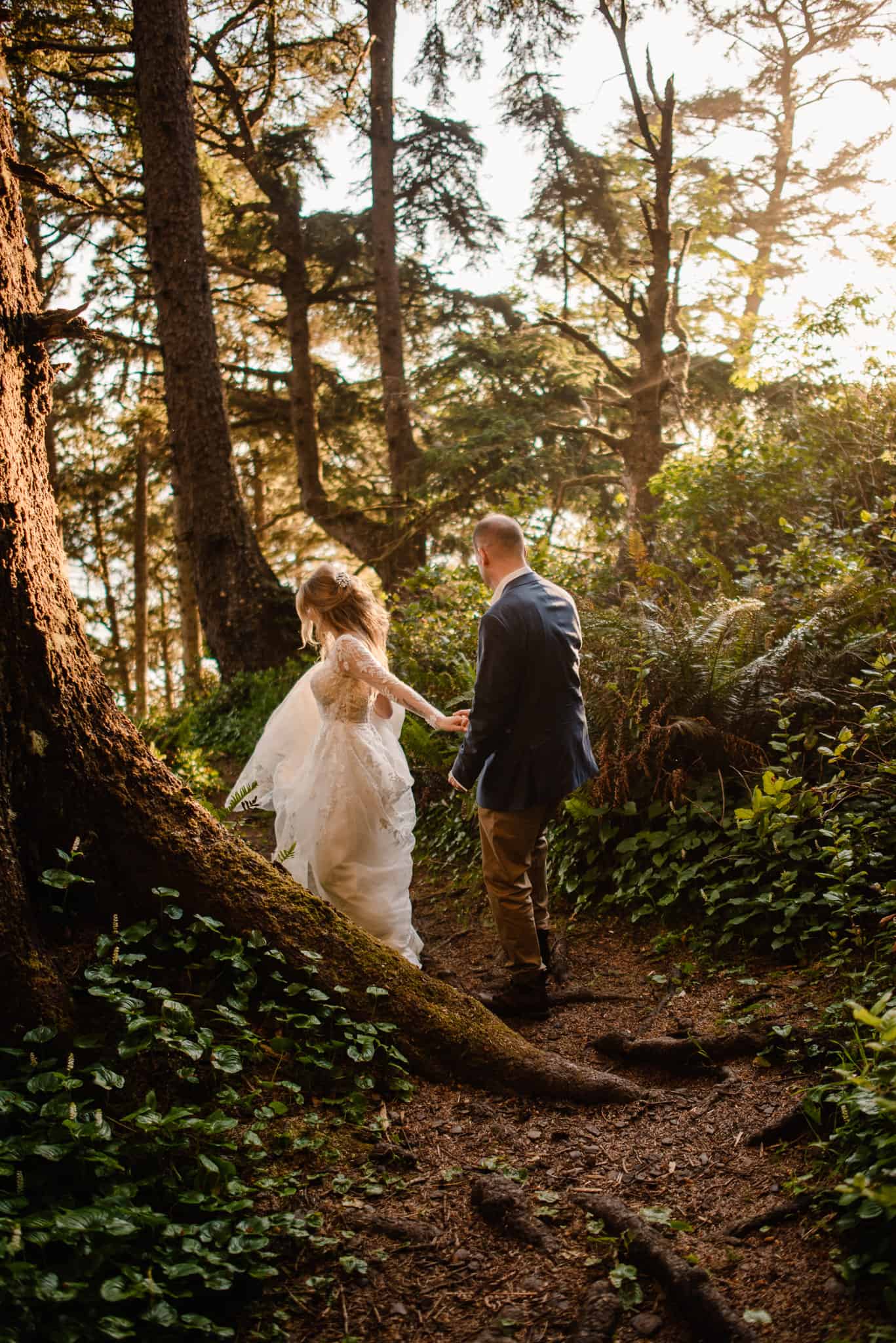 couple walking through forest as their Hawaii elopement photographer takes their photo