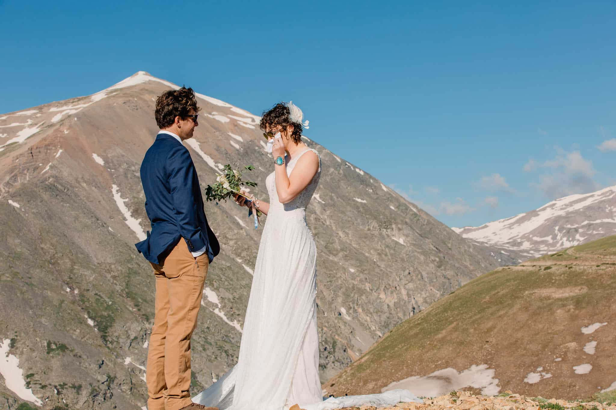 couple sharing private vows on top of a mountain with mountains in the background