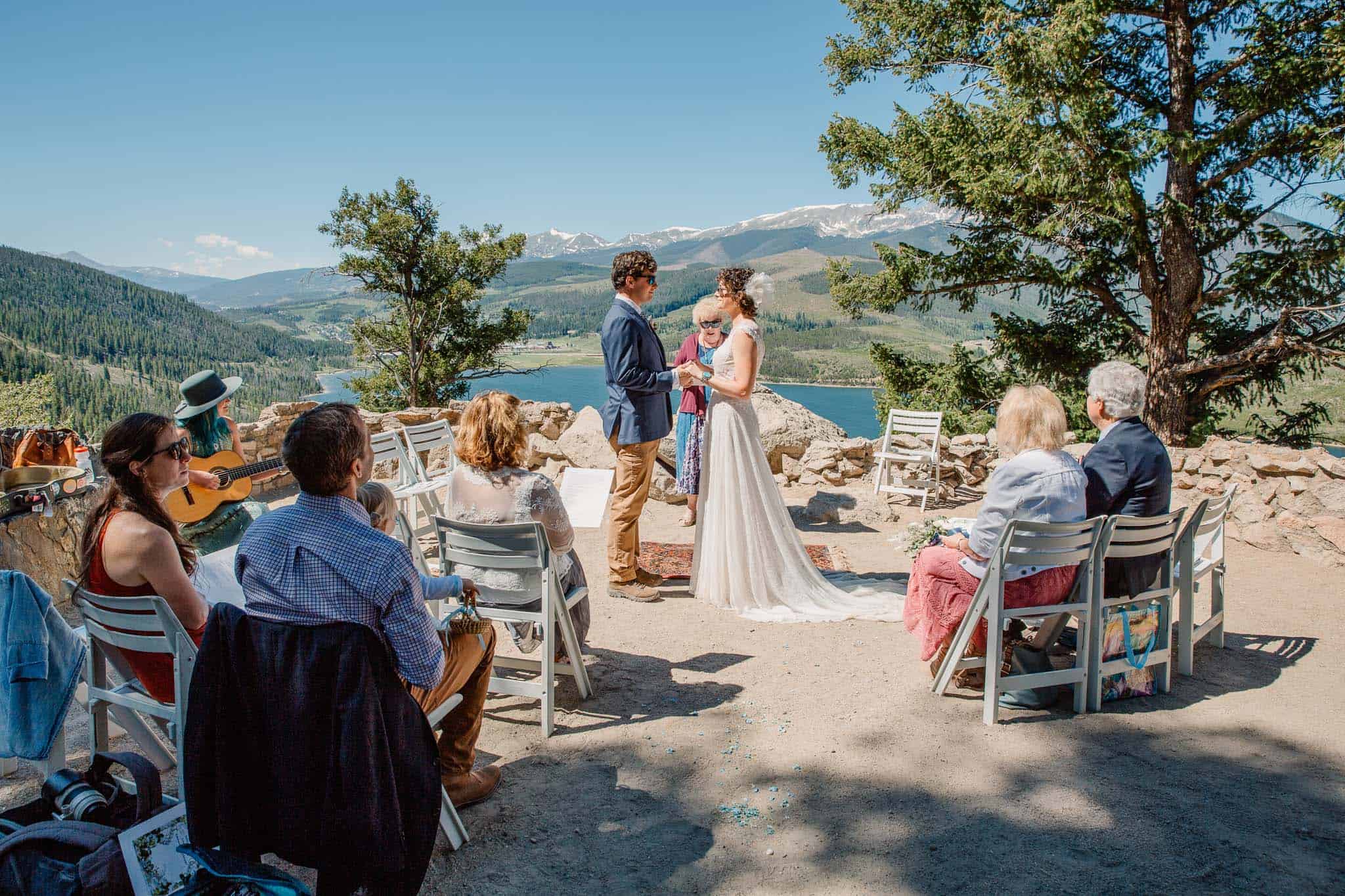 couple eloping with family with family in chairs sitting around them and mountain views in the background