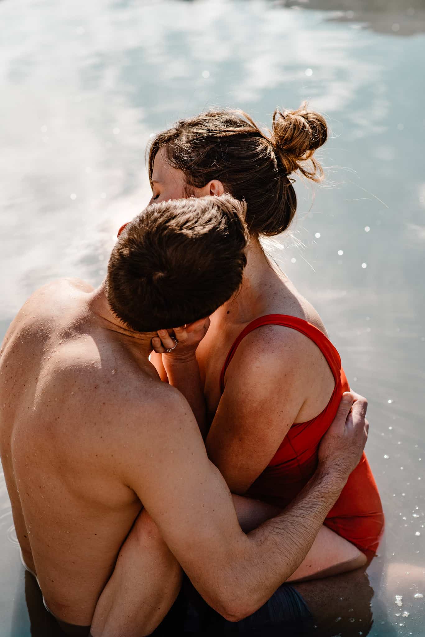 couple in water snuggling together in swim suits