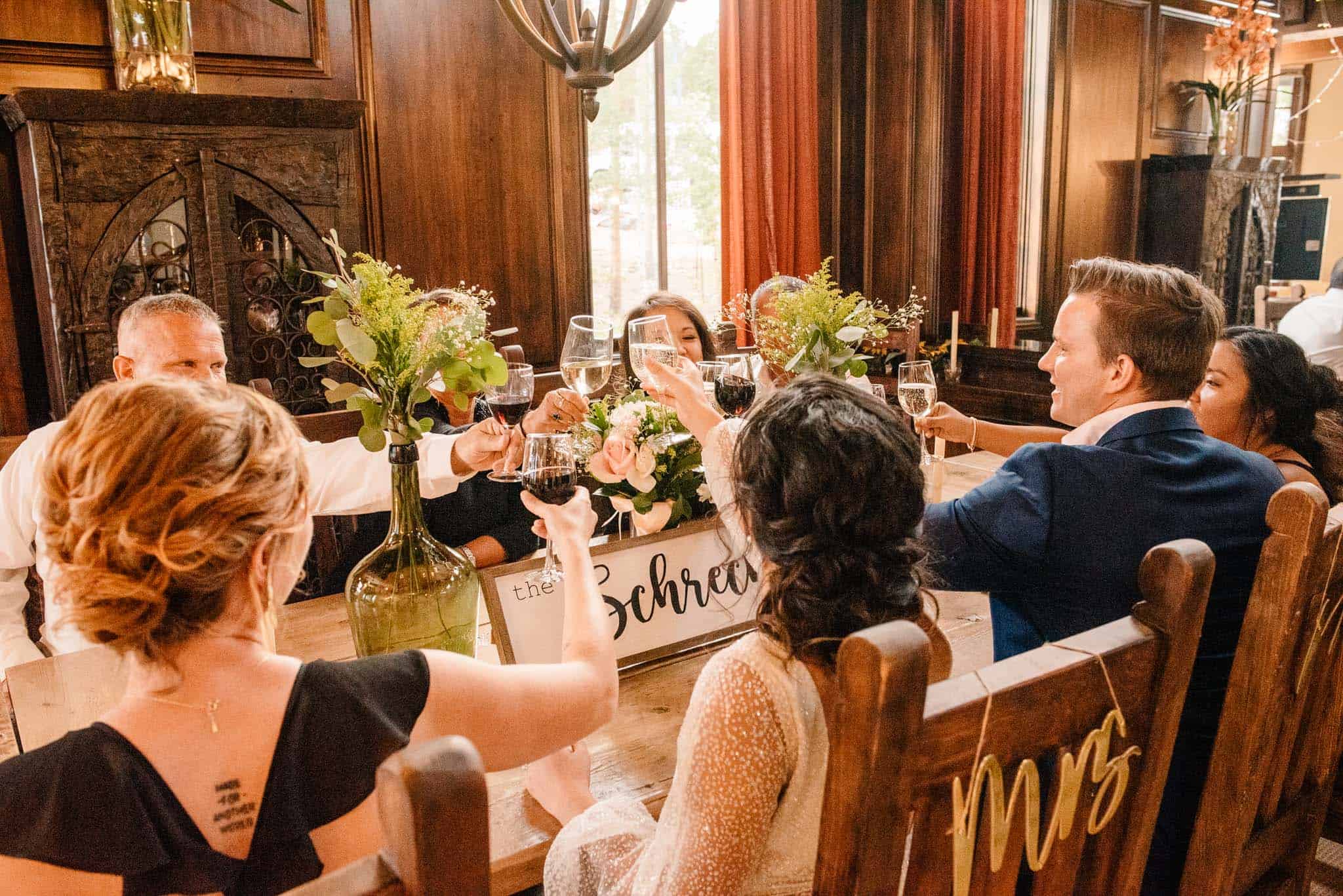 couple eloping with family cheering around a table