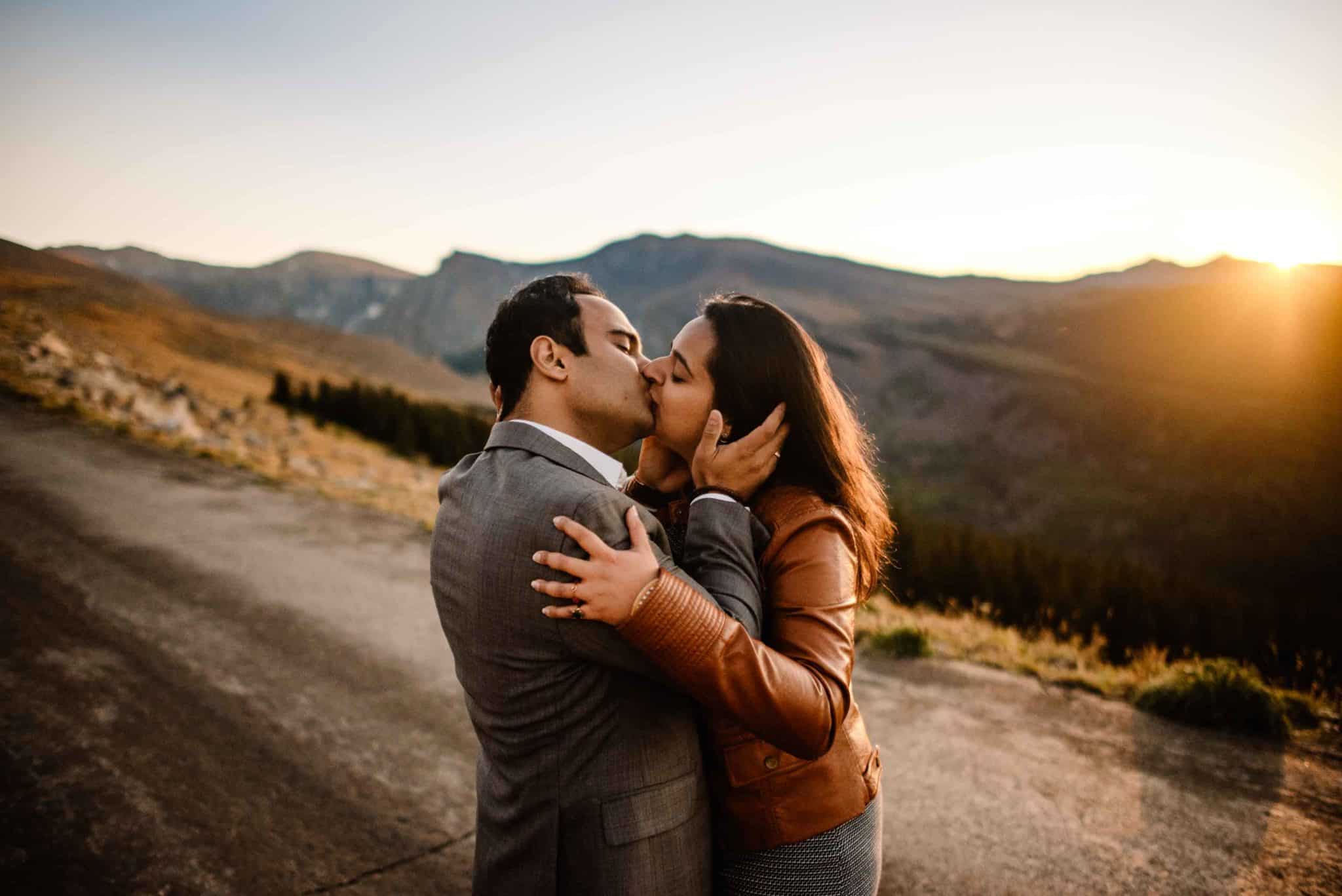 couple kissing during a sunset on top of a mountain during a couples connection experience