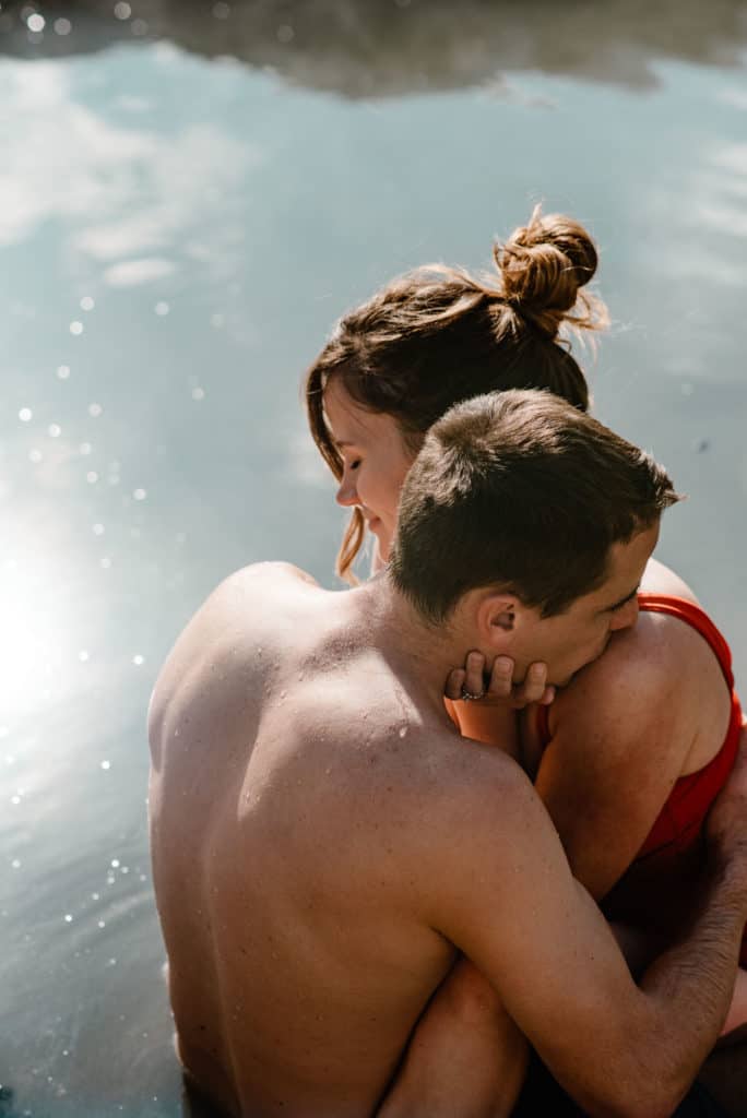 couples connection experience with male kissing female's shoulder in a hot spring