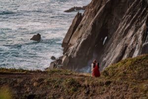 bride and groom on a cliff edge holding lanterns at their Oregon Coast Elopement