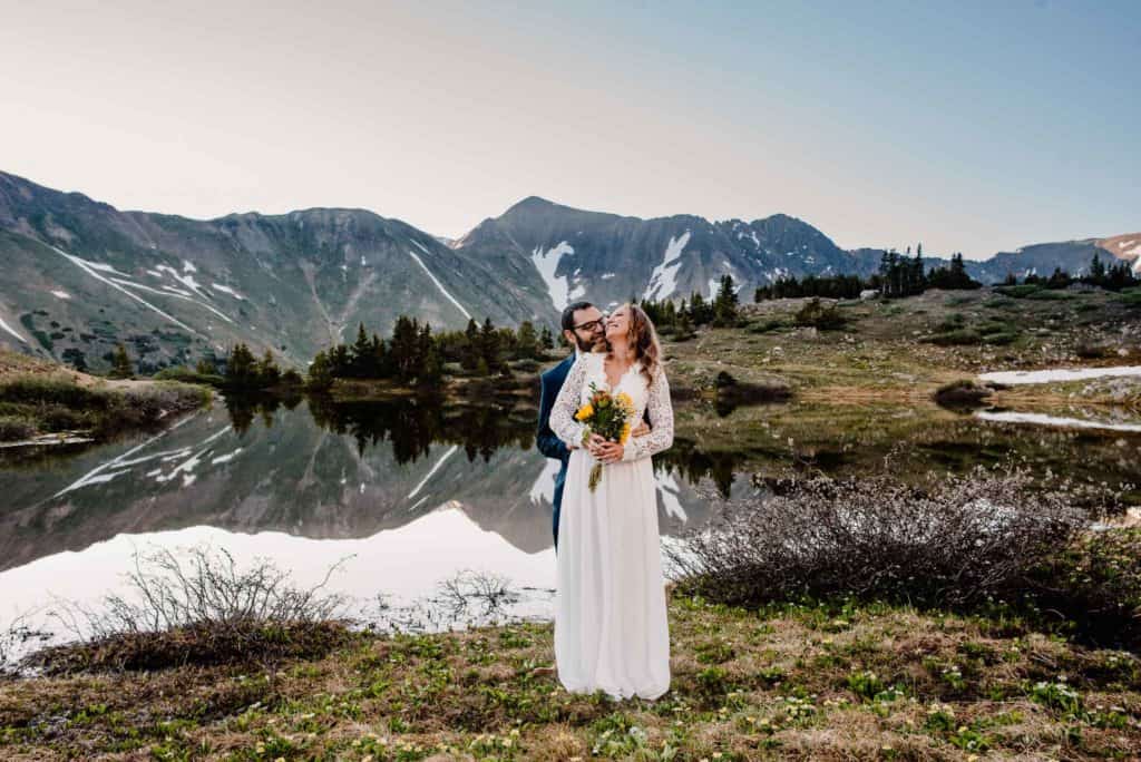 couple standing in front of alpine lake in Colorado for their Colorado elopement package