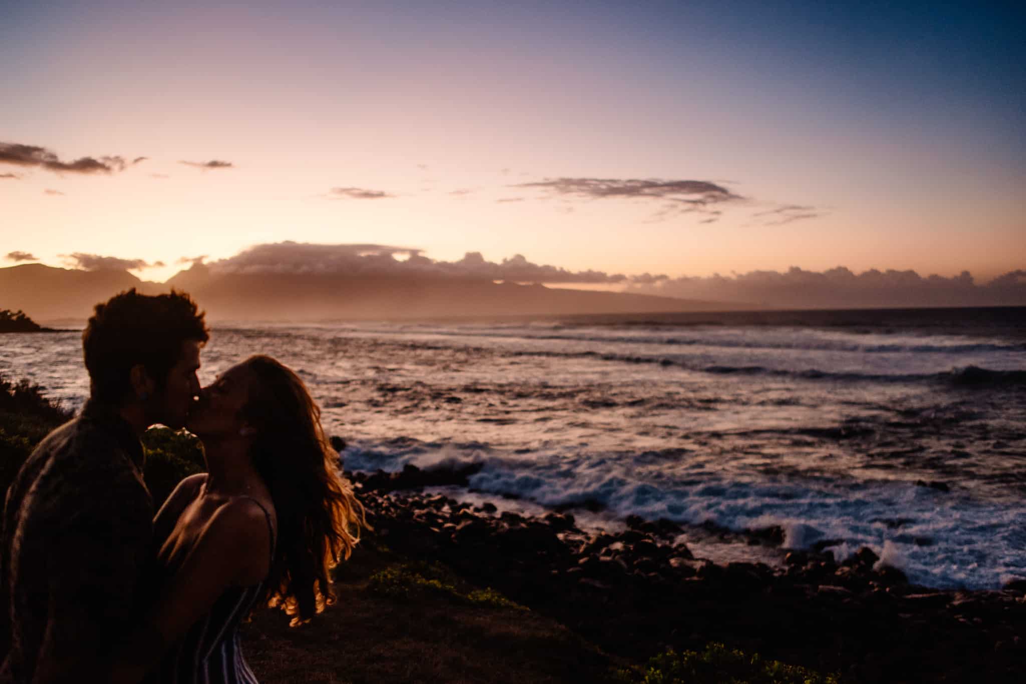 couple kissing silhouetted by a sunset