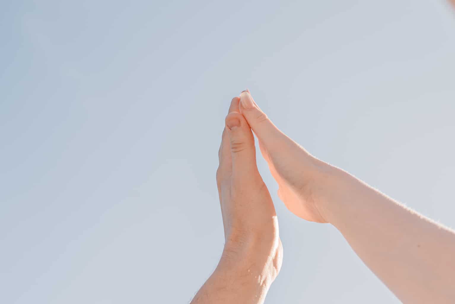 Couple placing hands together after feeling disconnected in relationship in partnership