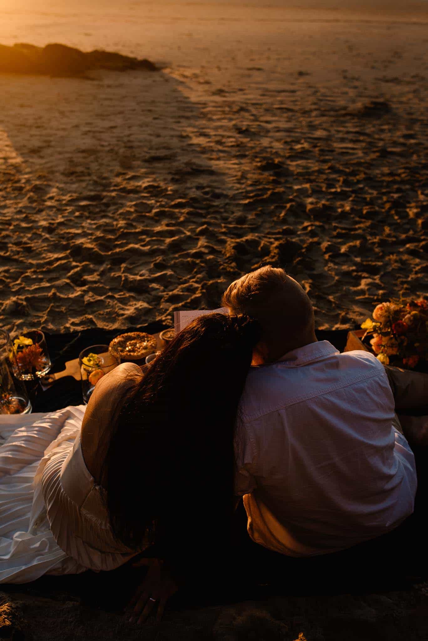 couple cudding contemplating self love in relationships on the beach as the sunsets glows on them