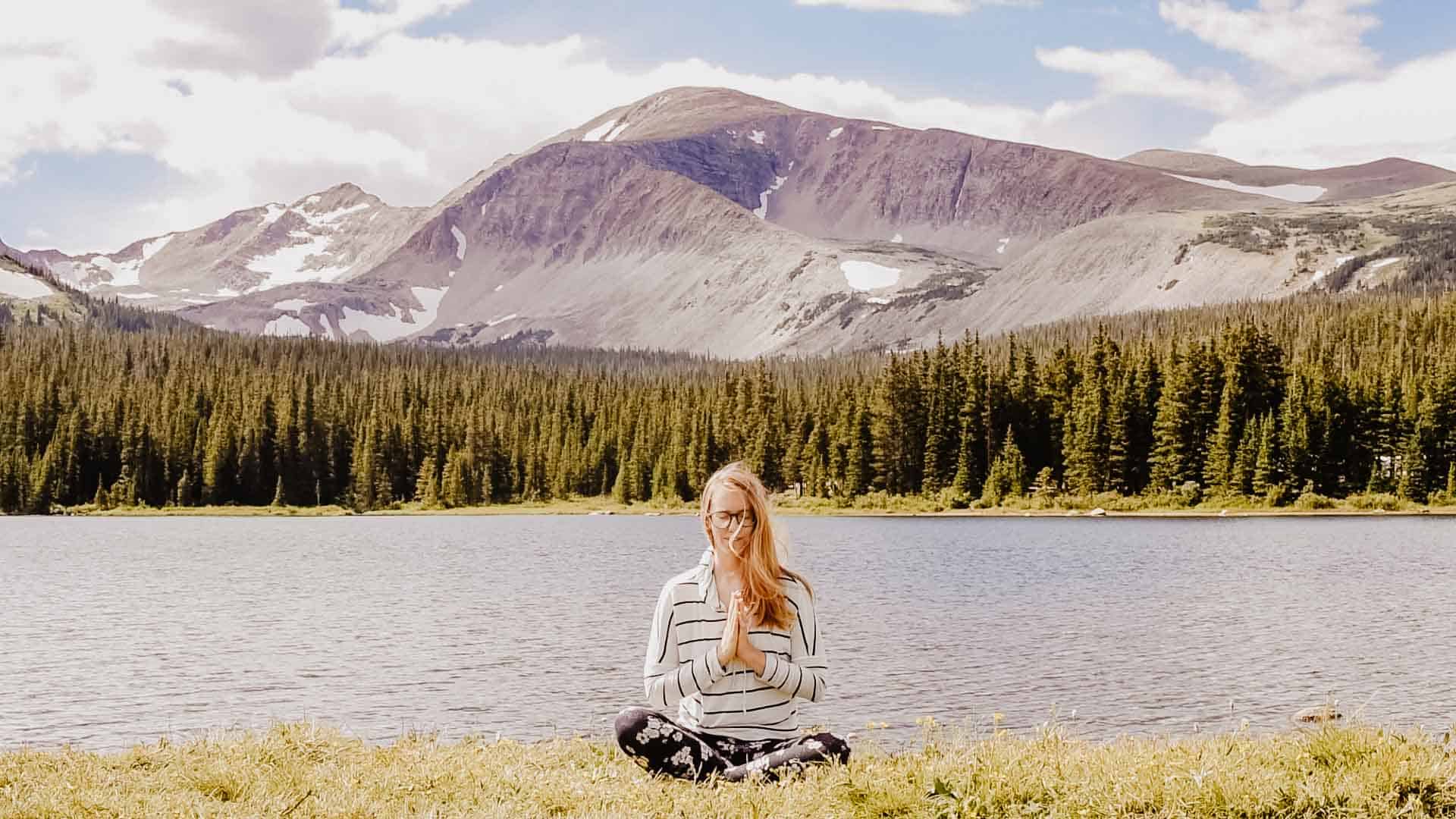 Lumalia sitting near mountain doing yoga and meditation as a part of the 30-day self-care challenge