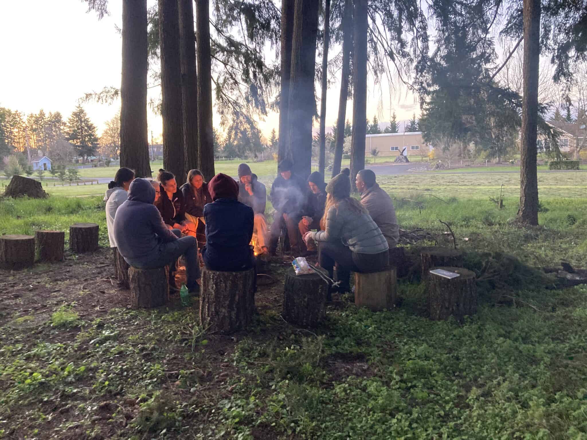 wellness retreats in oregon a couple of people around a campfire