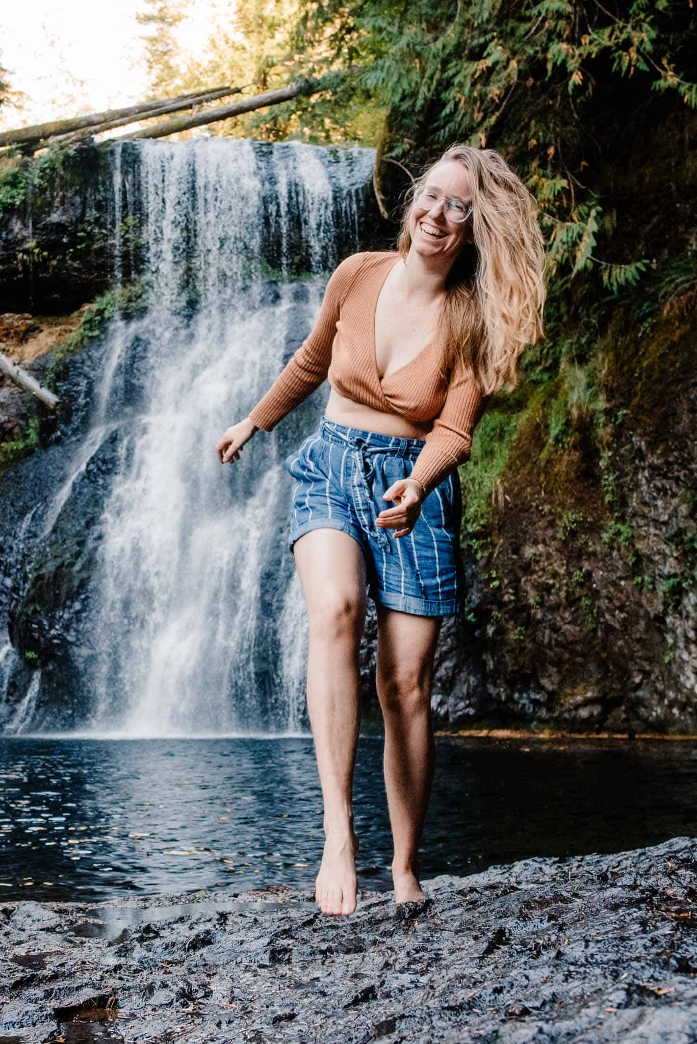 Lumalia smling with a waterfall in the background after a women's retreat in Oregon and wellness experience in portland oregon