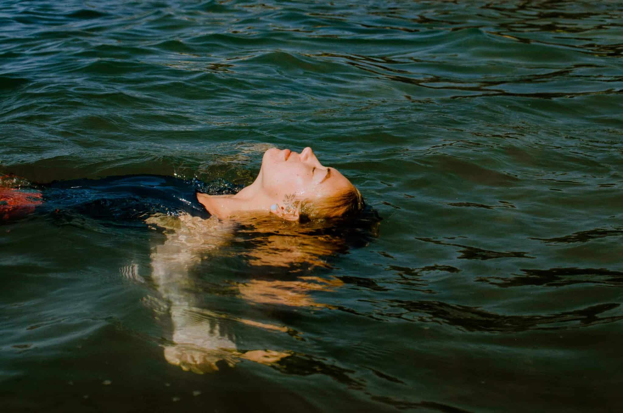 woman floating in water at a boudoir photography experience in Oregon