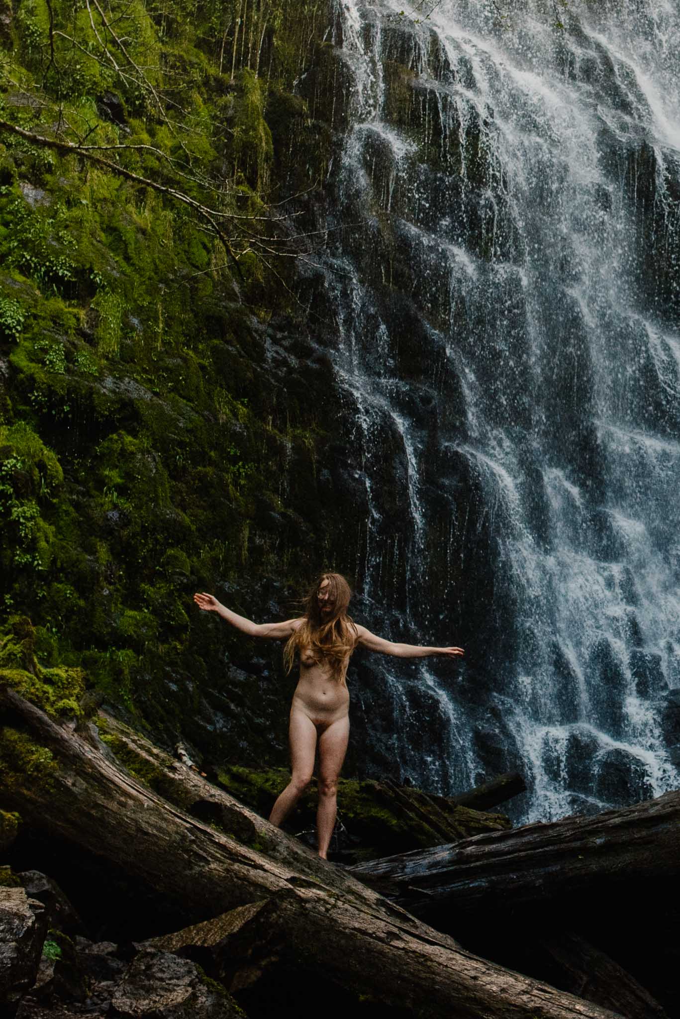 female in boudoir session near a waterfall