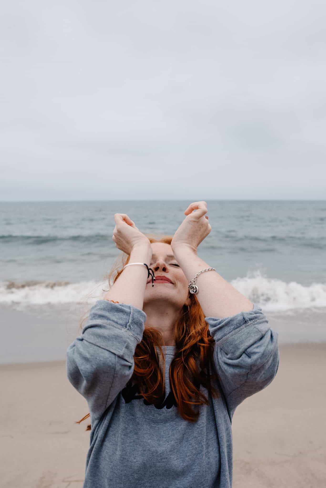 woman on the beach in a sensual moment during boudoir pricing based photography package in Oregon