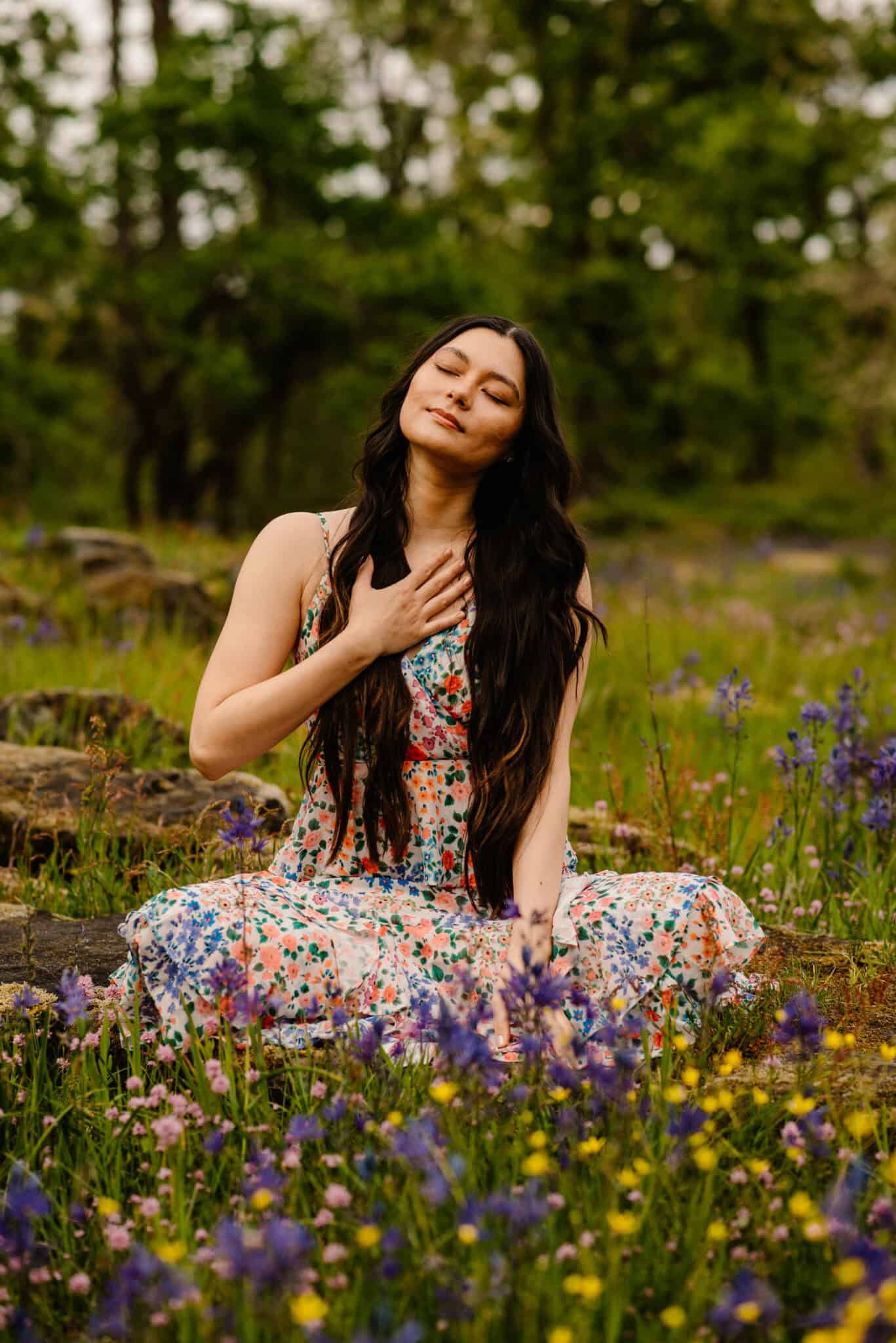 woman holding hand on her heart in wild flowers fter learning how to reconnect with yoruself when you feel lost