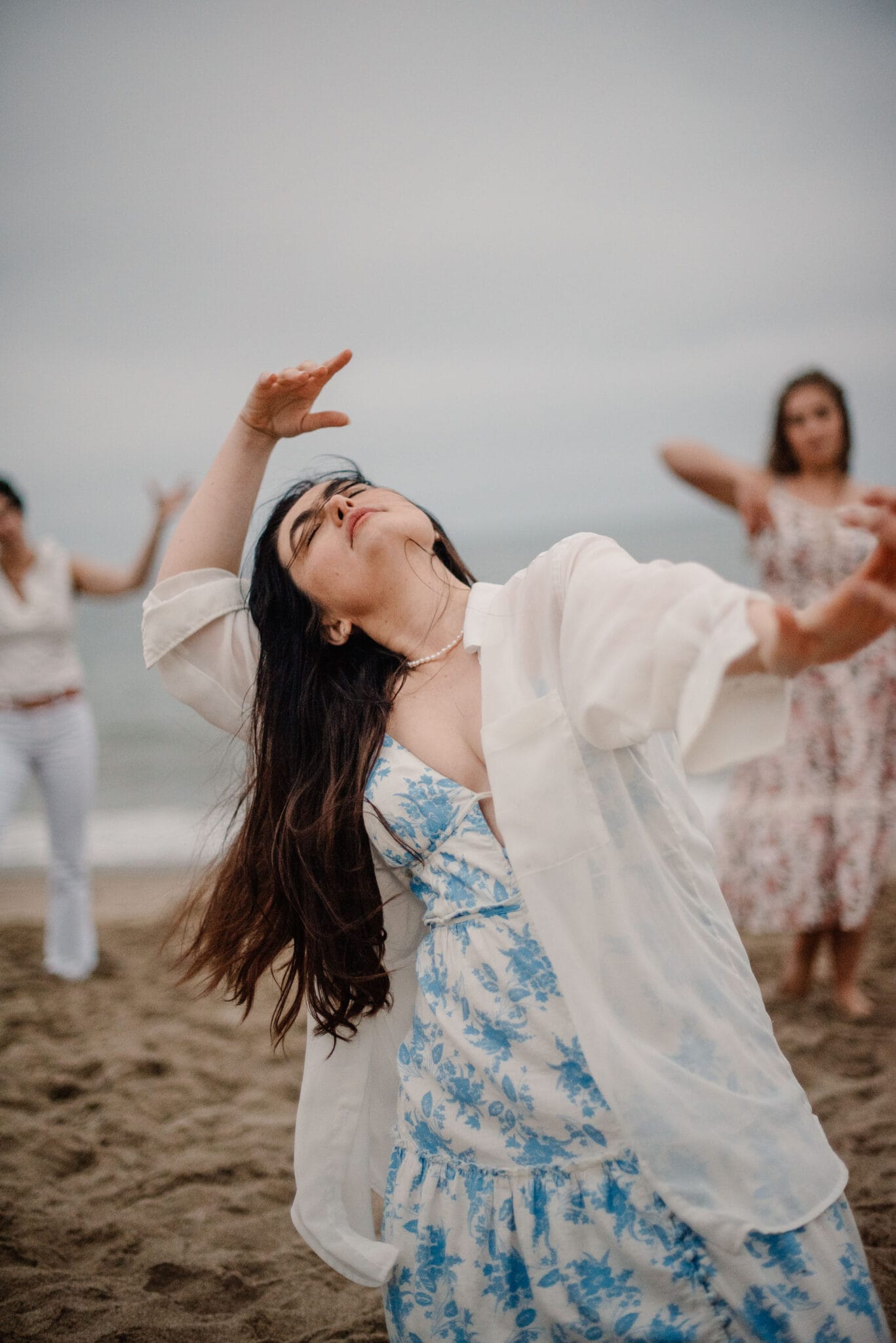 woman dancing on a beach with women supporting behind her after learning how to reconnect with yoruself when you feel lost