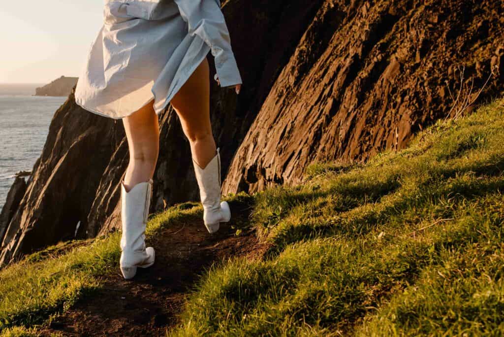 woman walking on coast during self-love boudoir photo shoot