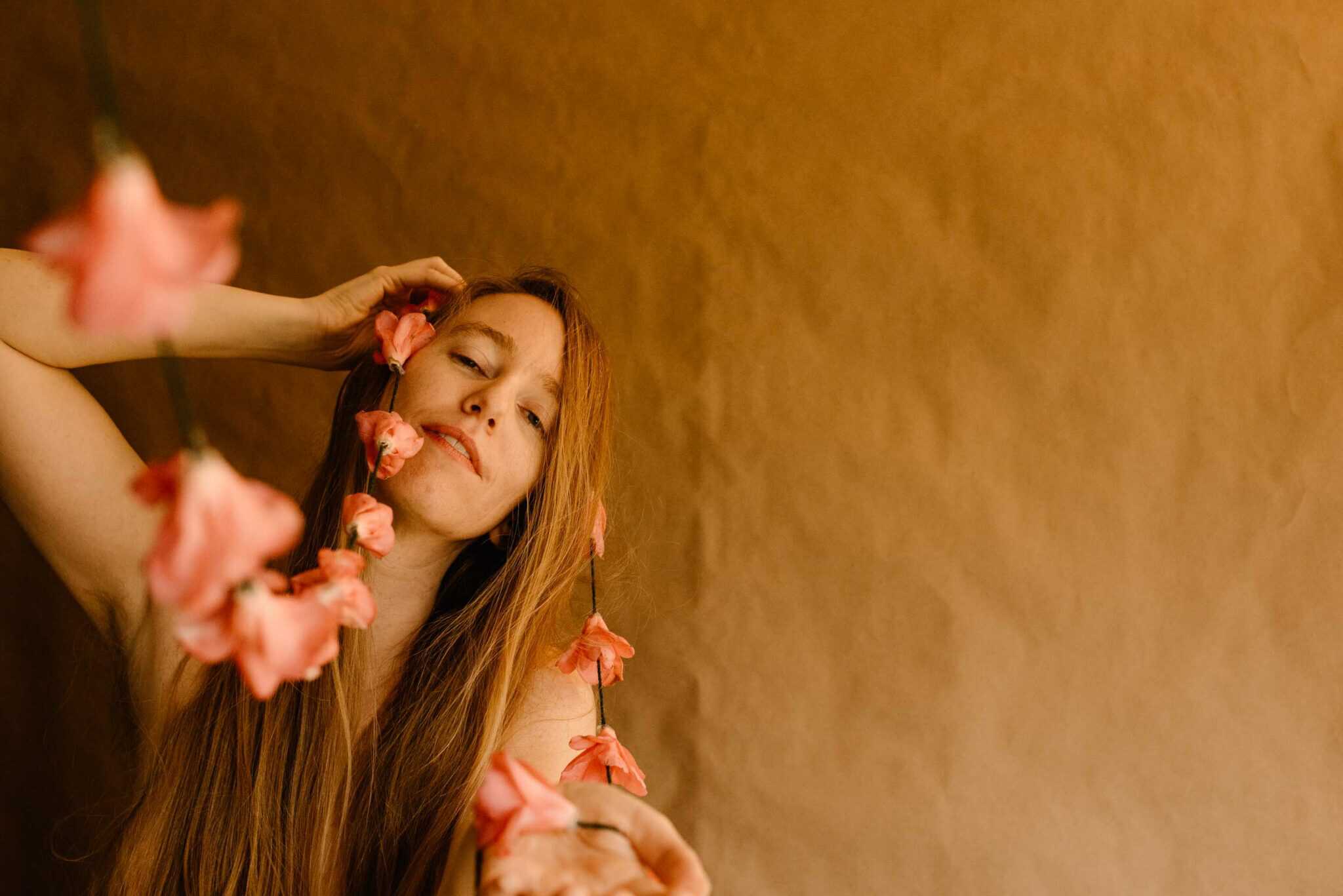 woman holding a camellia on a string in her hands