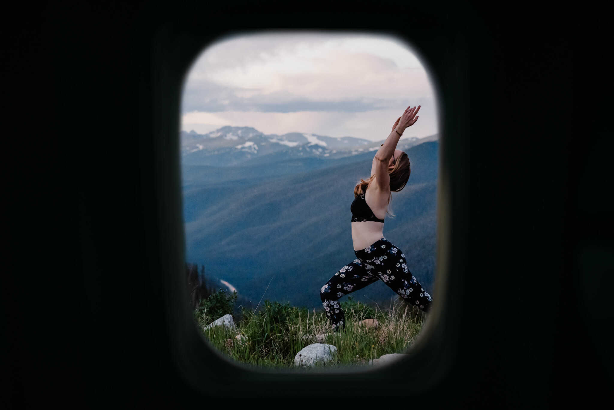 woman doing yoga on top of a mountain