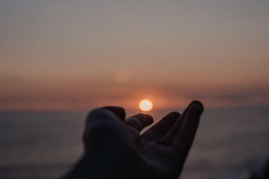 hand reaching out to the ocean a good symbol of the importance of community and self awareness