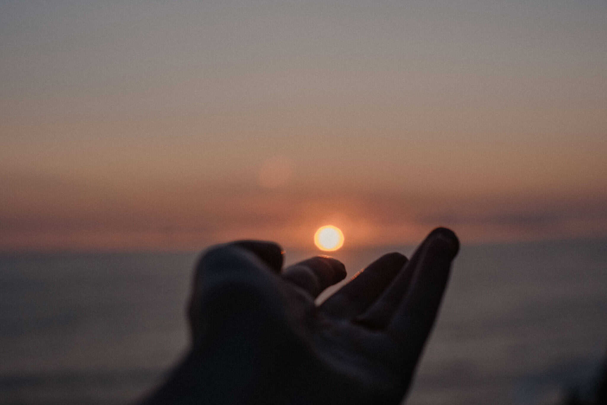 hand reaching out to the ocean a good symbol of the importance of community and self awareness