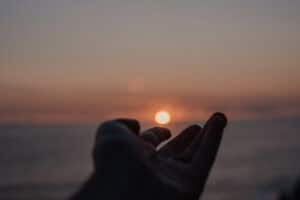 hand reaching out to the ocean a good symbol of the importance of community and self awareness
