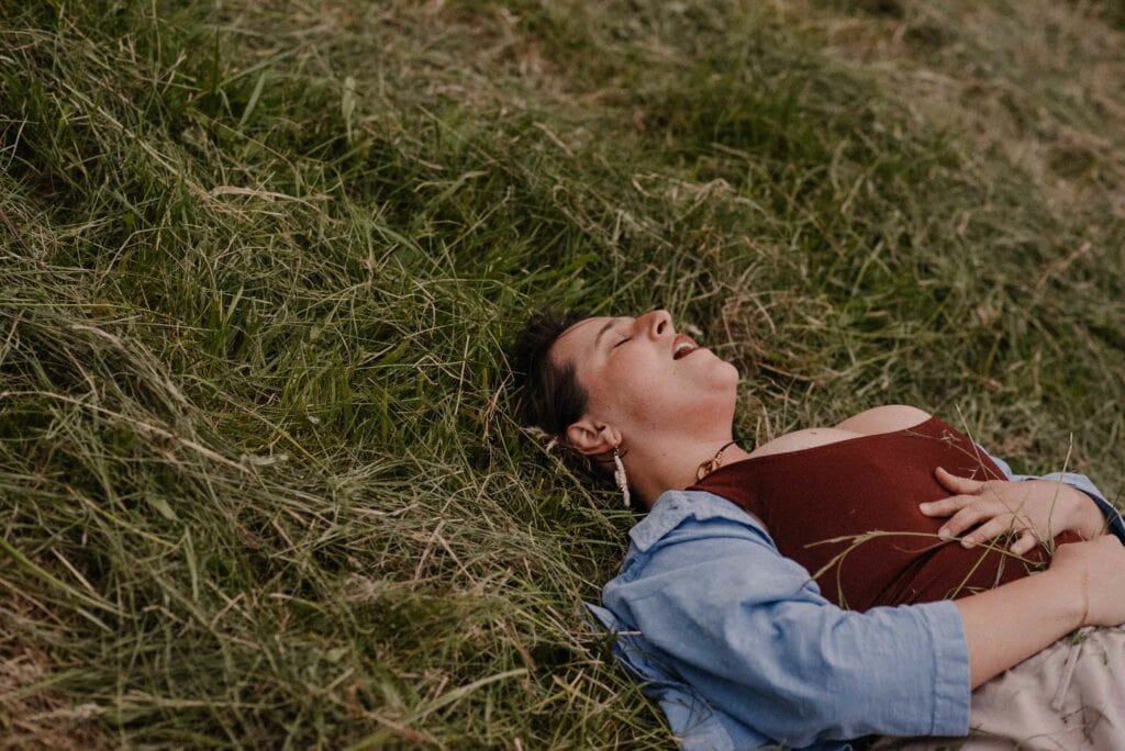 woman laying in ground releasing rage during a rage retreat using the power of the camas flower meaning during an emotional release ceremony
