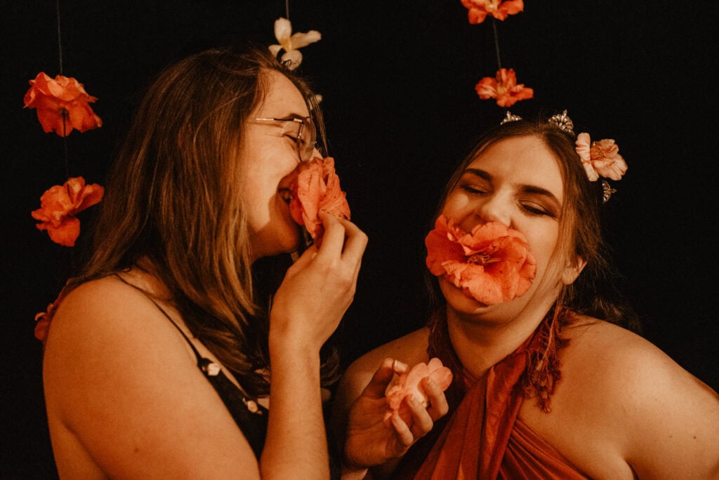 women laughing during an immersive art somatic experience in portland or with flowers in the mouth