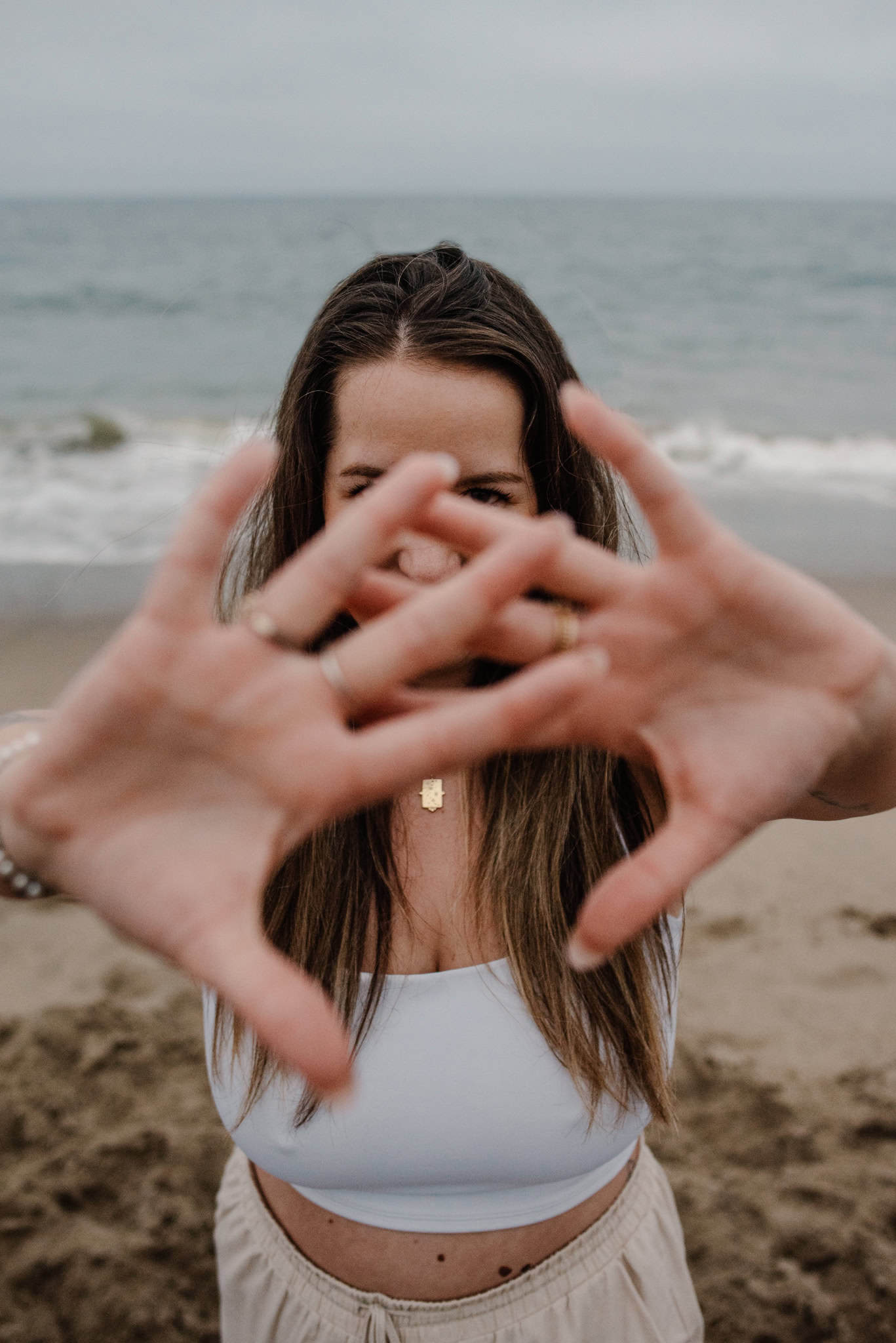 woman holding hands out during immersive art somatic experience near a beach