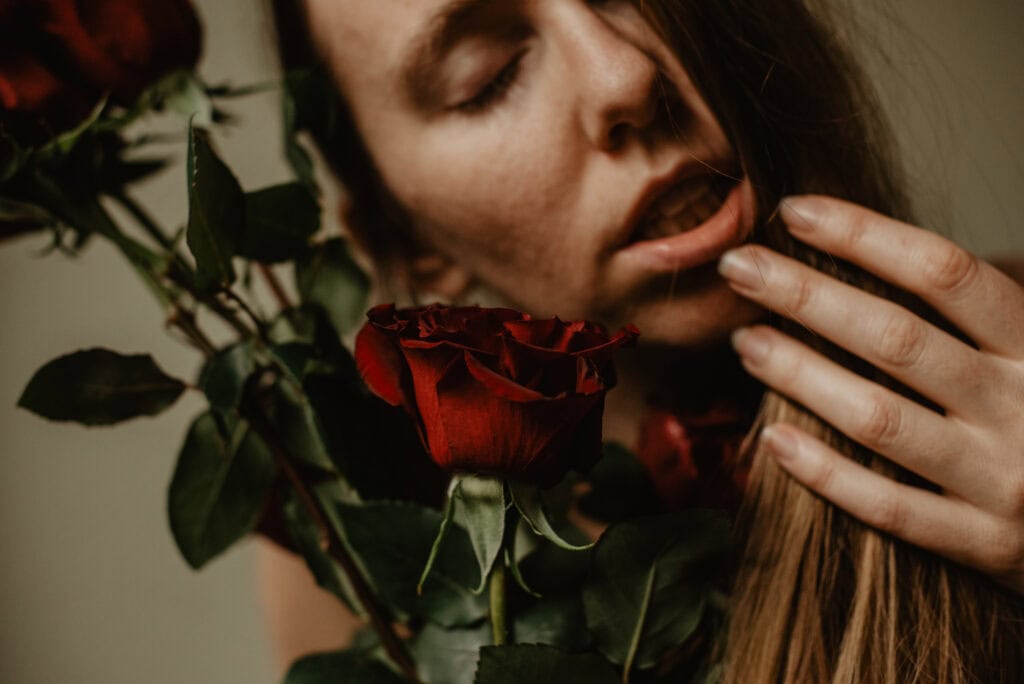 woman touching her lips near a rose during an immersive art somatic experience in portland