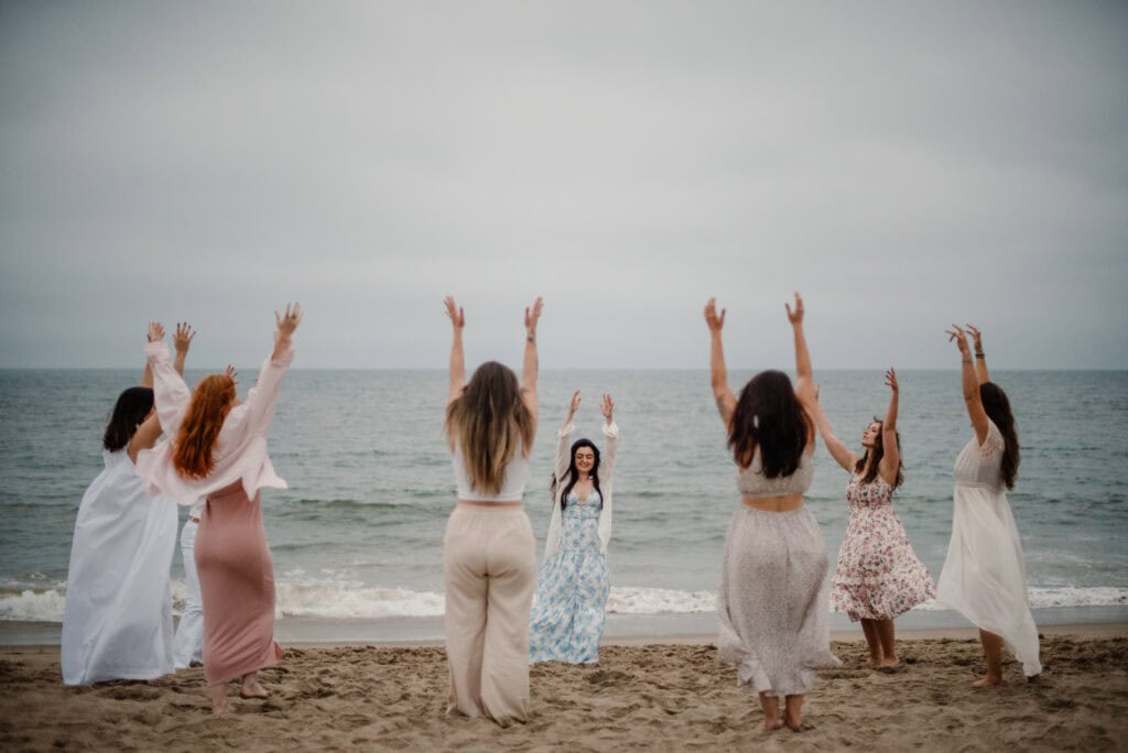embodied experiences with women dancing around a coast with a celebrate again experience photographed by Lumalia