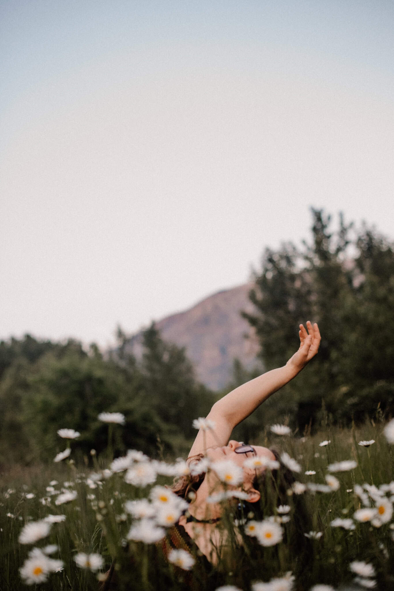 embodied experiences with one woman and daisies hands up during a celebrate again experience photographed by Lumalia