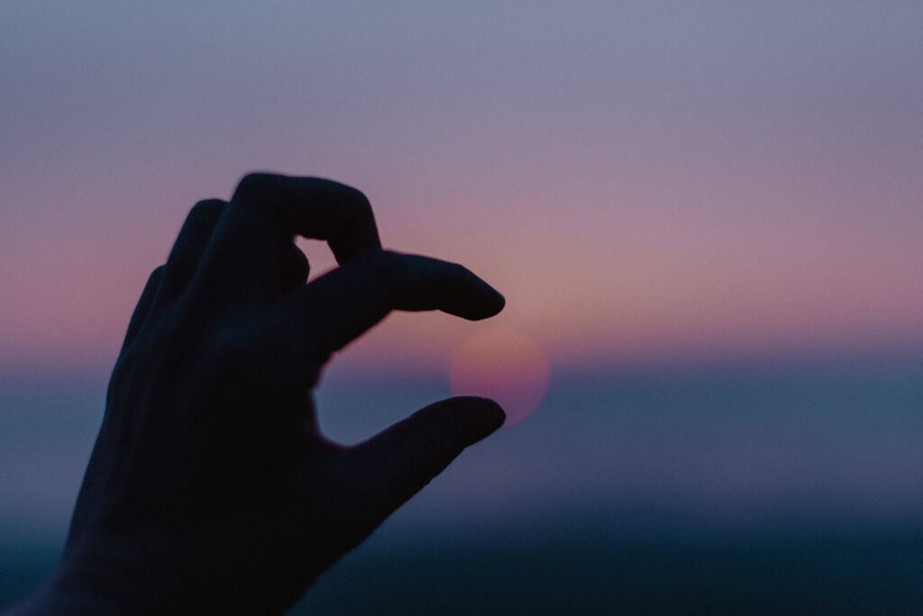 hand reaching out to sunset for a Celebrate Again embodied experienced photography by Lumalia