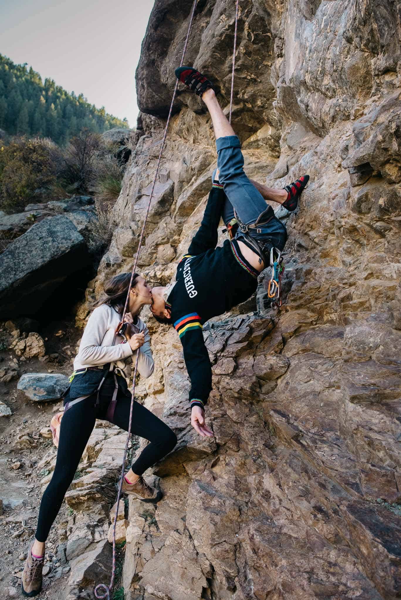 couple rock climbing one partner upside down during Portland couples engagement photography session with Celebrate Again