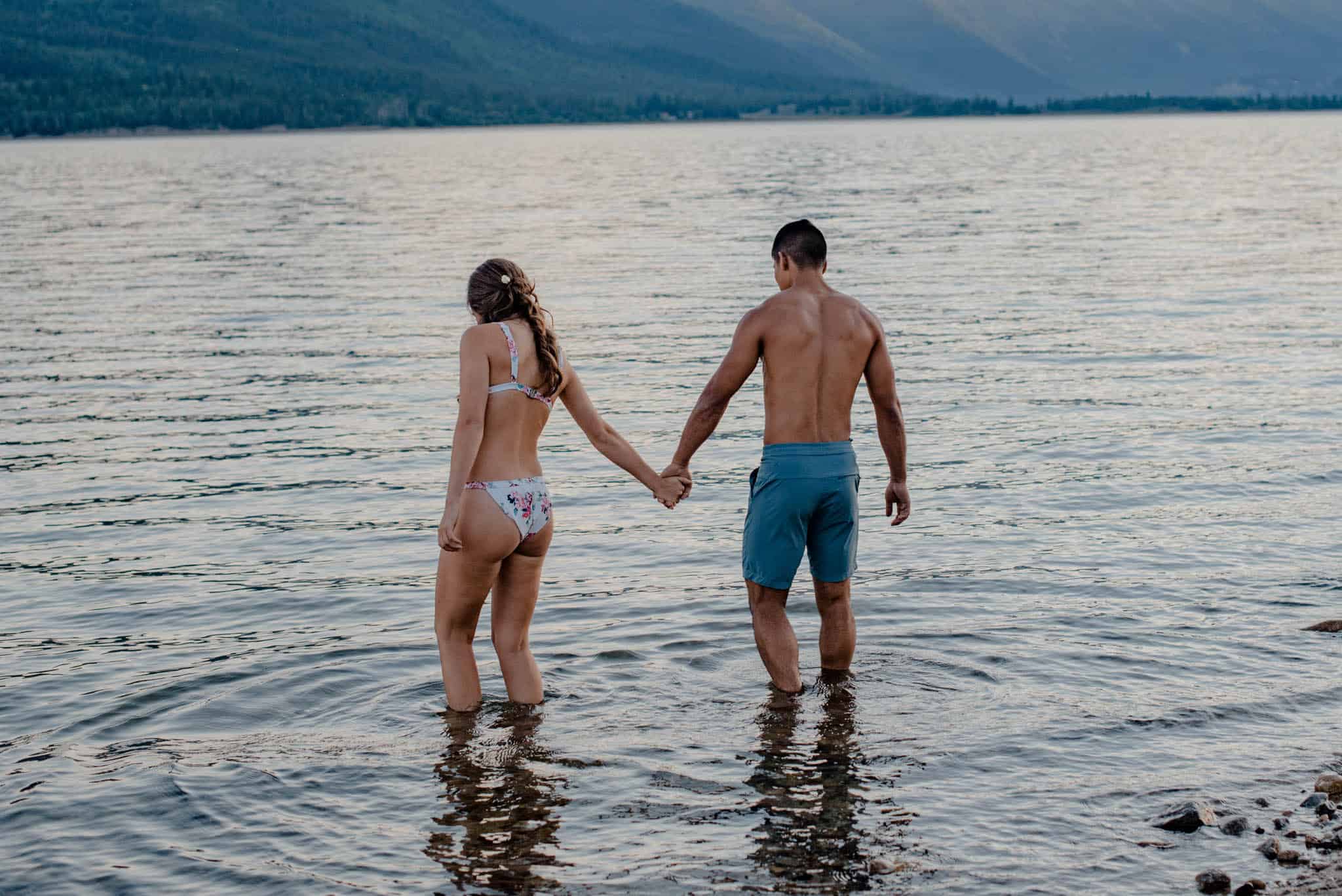 couple splashing in water during engagement photos in Cathedral Park
