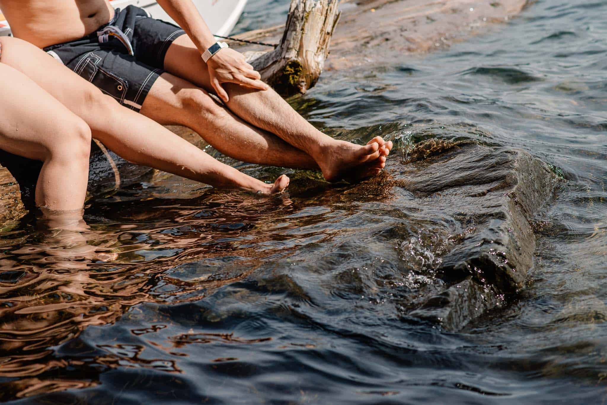 couple splashing in water near the river front at Cathedral park during engagement photos in Cathedral Park