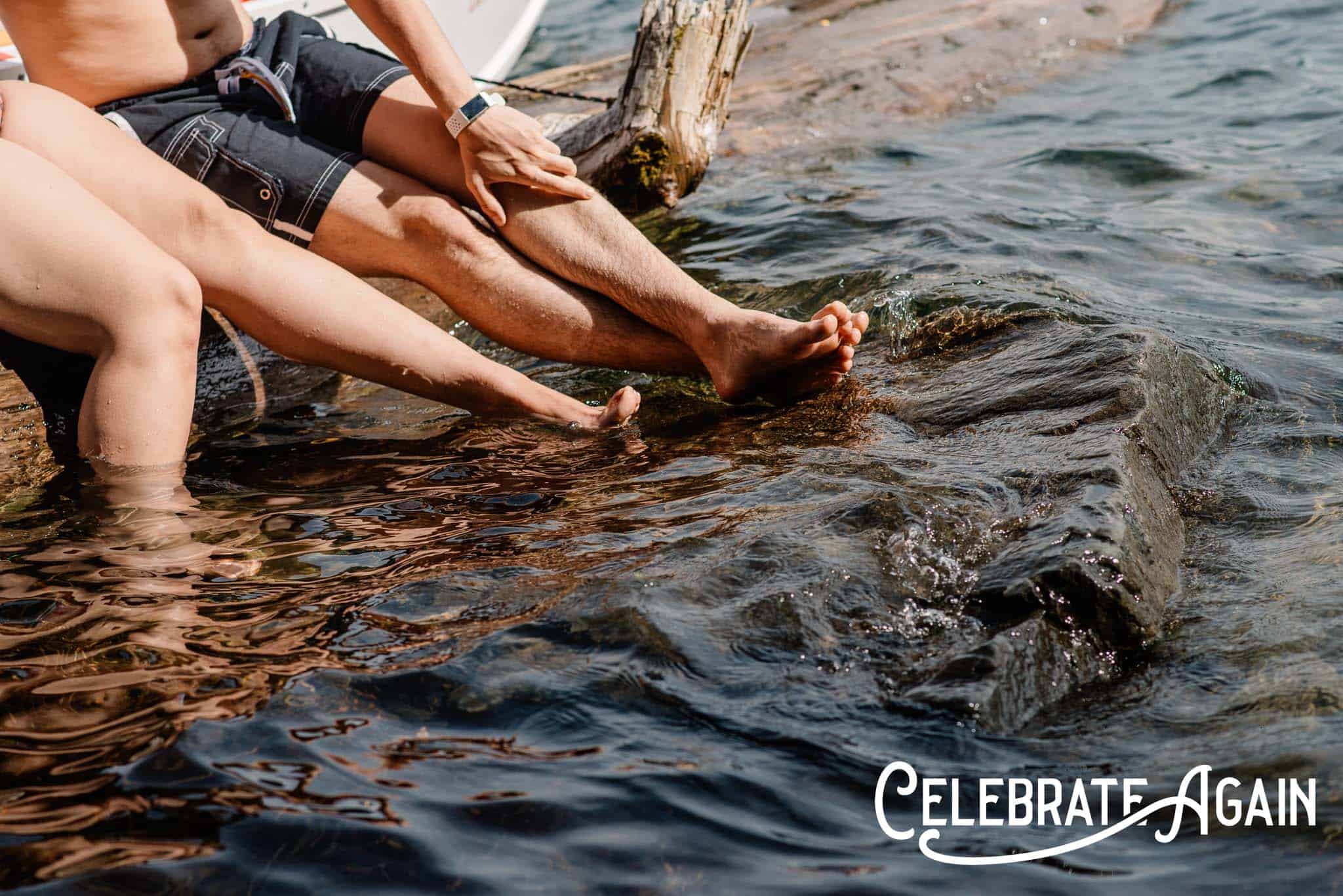 couple dipping their toes in at Sellwod River front at a engagement photo location in Portland, Oregon with Celebrate Again